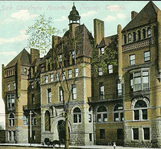 A postcard of a large victorian building. The entrance is recessed with an archway. The building is around 5 stories and has a roof with multiple pointed areas.